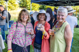 Women with wine glasses at tasting event on upper lawn