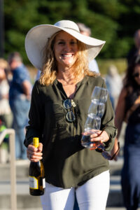 Patron smiling with hat and wine