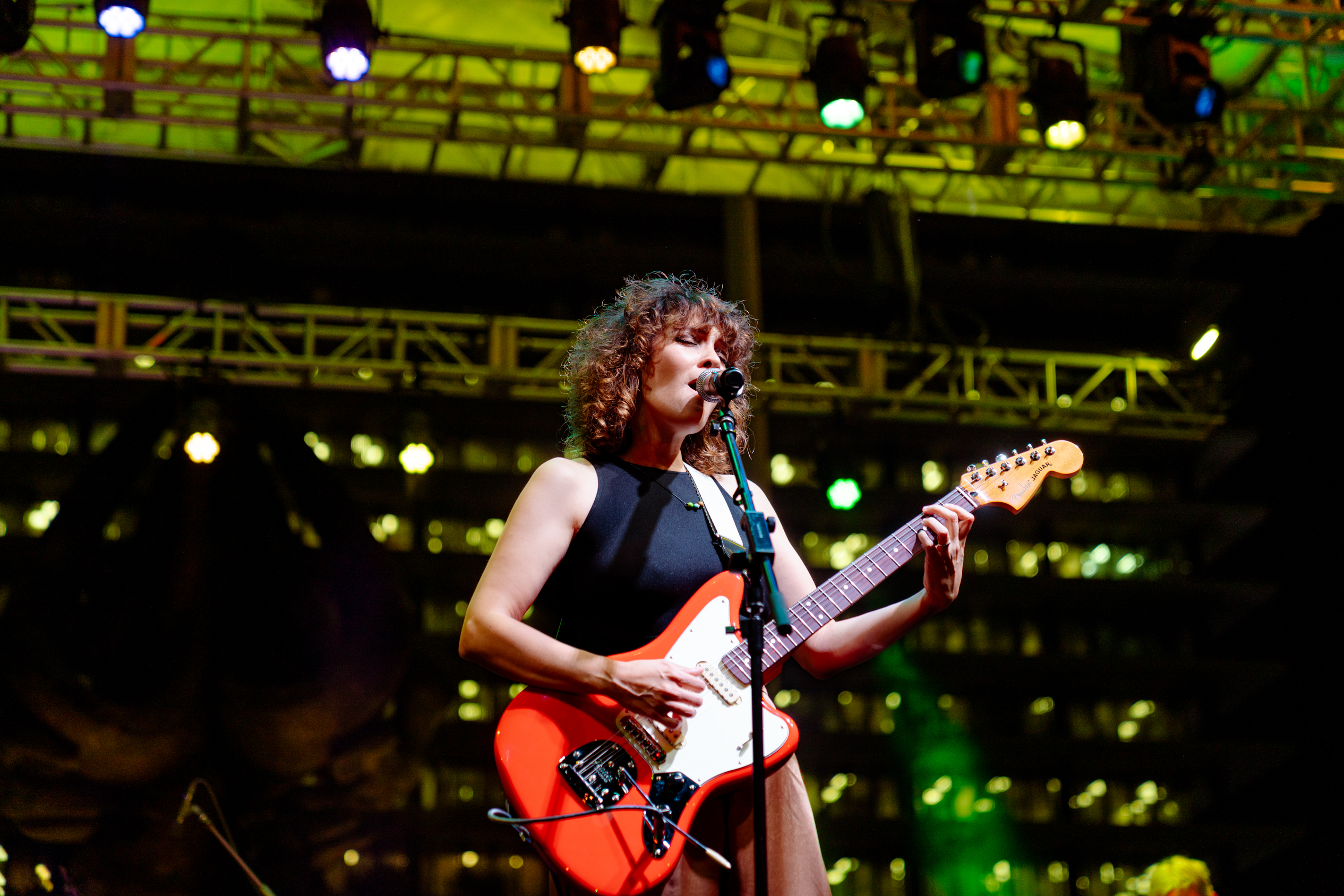 Gaby Moreno performing on stage with a guitar and a microphone