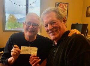 Gayle & Arnie Carston smiling with check