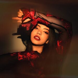 Lucía with her arm leaning across her head in a spotlight